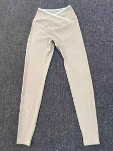 Detailed close-up of V-shaped crossover high waistband with white contrast trim on yoga pants
