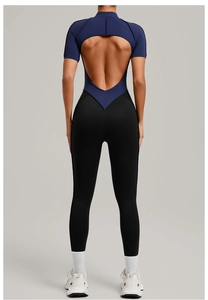 Detail of cross-back cutout and contrast paneling on navy blue yoga jumpsuit