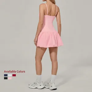 Pink sleeveless golf tennis dress with thin straps and ruffled hem in studio back view