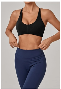 Close-up of black U-neck sports bra and navy high-waisted yoga pants on model