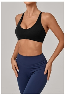 Detail of cross-back yoga bra and high-waisted navy leggings for fitness training