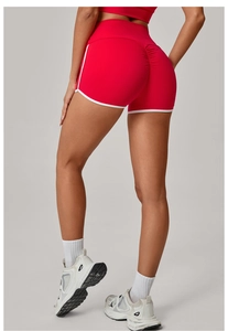 Detail view of red high-waist yoga shorts with white contrast trim and scrunch butt effect