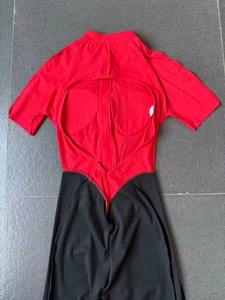 Flat lay detail of red and black color-block sports bodysuit with open back design