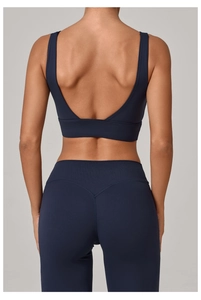 Vue arrière du soutien-gorge de yoga bleu foncé et legging taille haute sur un mannequin