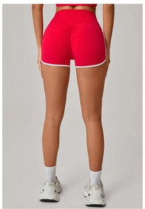 Detail showing red high-waisted yoga shorts with scrunch butt lift and white contrast trim