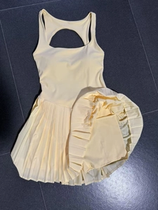 Detail view of yellow backless pleated tennis dress with built-in safety shorts