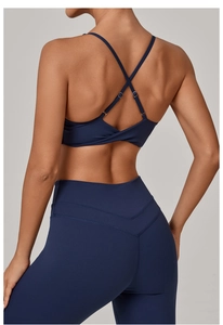 Detail of cross straps and twist design on a navy blue backless sports bra set