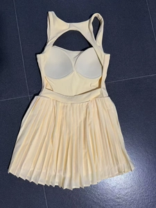 Detail view of cream backless tennis dress with built-in pads and pleated skirt design