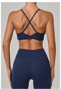 Detail of cross back yoga bra and high waist leggings in navy blue with twist design