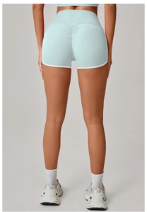 Close-up of high-waist yoga shorts with peach lift seam and white contrast piping