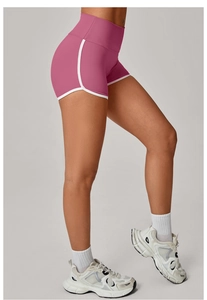 Detail view of high-waisted yoga shorts with peach-lift cut and white contrast piping trim