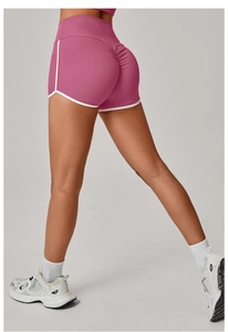 Detail view of pink high-waist yoga shorts with white piping and scrunch butt design
