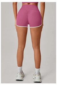 Detail view of pink yoga shorts featuring scrunch butt lifting and white contrast trim