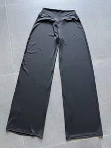 Détail du pantalon de yoga noir à jambe large avec texture lisse et soyeuse