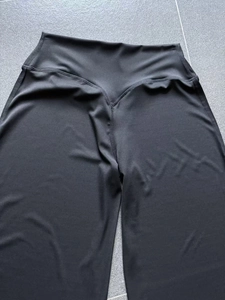 Détail de la taille en V sur un pantalon de yoga noir à taille haute avec coutures renforcées