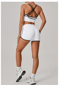 Detailansicht der High-Waist Scrunch Butt Yoga-Shorts und BH mit schwarzen Kontrastpaspeln