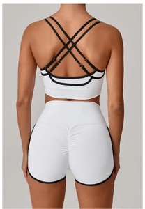 Detail der überkreuzten Träger und Scrunch-Butt-Lifting-Shorts am weißen Yoga-Set