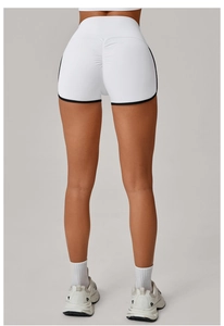 Close-up of white yoga shorts with black piping and ruched butt lifting seam detail