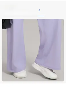 Détail du pantalon de yoga violet clair à jambes larges et taille haute avec baskets