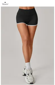 Close-up of high-waist black yoga shorts with white trim detailing and peach lift effect