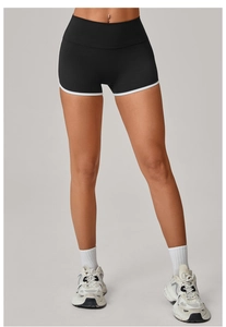 Detail view of high-waist black yoga shorts with white contrast piping for women