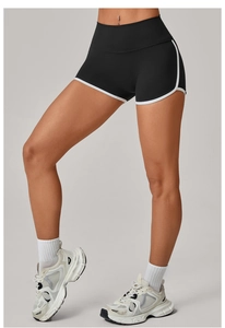 Detailed close-up of high-waist black yoga shorts with white contrast piping for women