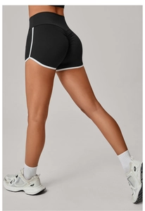 Detail showing scrunch butt design and white contrast piping on black yoga shorts