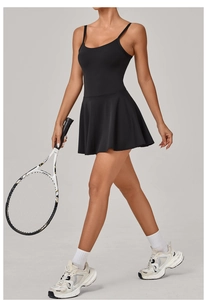 Detail of cross-back straps and pleated hem on a black athletic tennis dress