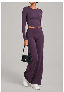 Détail d'un ensemble de yoga violet foncé avec haut court à manches longues et pantalon évasé