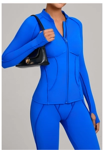 Détail de la veste de yoga bleue zippée avec passe-pouces et coutures incurvées sport