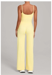 Back view of bright yellow yoga set featuring thin strap vest and flared sports pants
