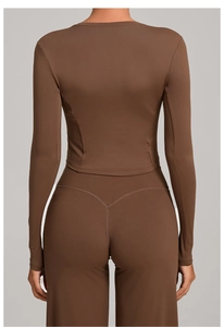 Macro view showing the back fit of a tight brown yoga long sleeve top and flare pants