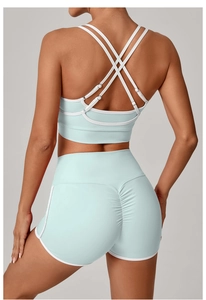Detail von minzgrünem Yoga-Set mit Cross-Back-BH und gerafften Push-Up-Shorts