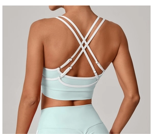 Détail des bretelles croisées du soutien-gorge de sport bleu clair à liseré blanc