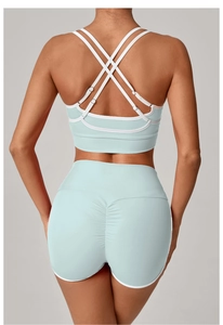 Detail von hellblauem Yoga-Set mit gekreuzten Trägern und Push-Up-Sportshorts