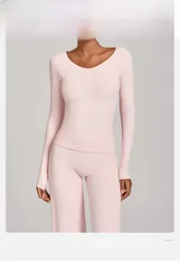 Détail du haut de yoga rose à manches longues avec col en V et pantalon évasé