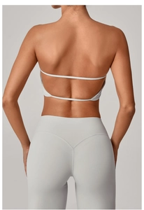 Vista posteriore del reggiseno sportivo grigio chiaro con spalline sottili e leggings a vita alta