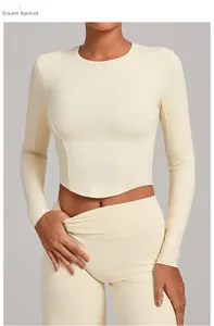 Close-up of tight-fitting long-sleeve creamy apricot yoga top with slim fit curved hem