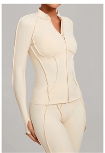 Détail du col montant zippé et des poignets passe-pouce sur veste de yoga beige