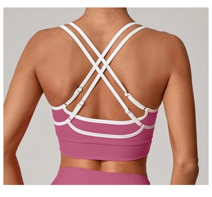 Détail du soutien-gorge de sport rose avec bretelles blanches et dos croisé élégant