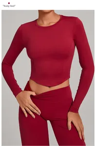 Detail of ruby red slim fit yoga set featuring curved hem top and high waist leggings