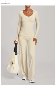 Detail von Yoga-Set in Creme-Aprikose mit Langarm-Oberteil und weitem Bein aus Stoff