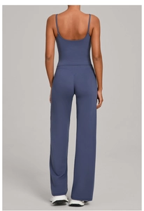 Rear view of dark blue yoga set featuring a backless sports tank and V-waist flared pants