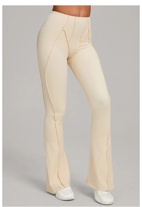 Detail of cream high-waisted flared yoga pants with exposed decorative seam stitching