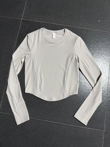 Close-up of a cropped fitness top with curved stitching on light gray knit fabric