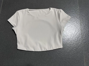 Dettaglio del top da yoga corto a maniche corte in tessuto grigio chiaro elasticizzato