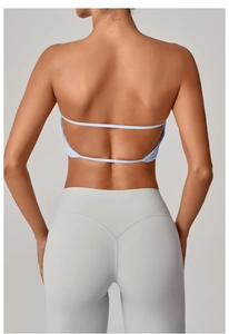 Dettaglio del reggiseno sportivo azzurro con spalline sottili e leggings yoga grigi alti