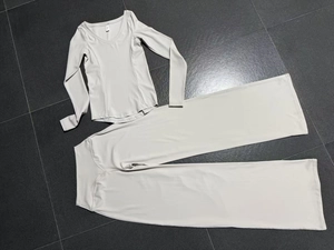 Detailansicht eines hellgrauen Yoga-Sets mit V-Ausschnitt Oberteil und weit geschnittener Hose