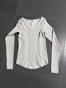 Détail du haut de yoga blanc à col en V avec tissu élastique et étiquette de taille