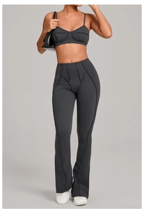 Détail de l'ensemble de yoga gris foncé avec haut de sport et pantalon évasé à coutures